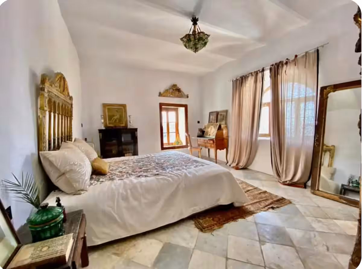 Chambre principale de la suite Omar El Khayam, tête de lit dorée et sol de marbre