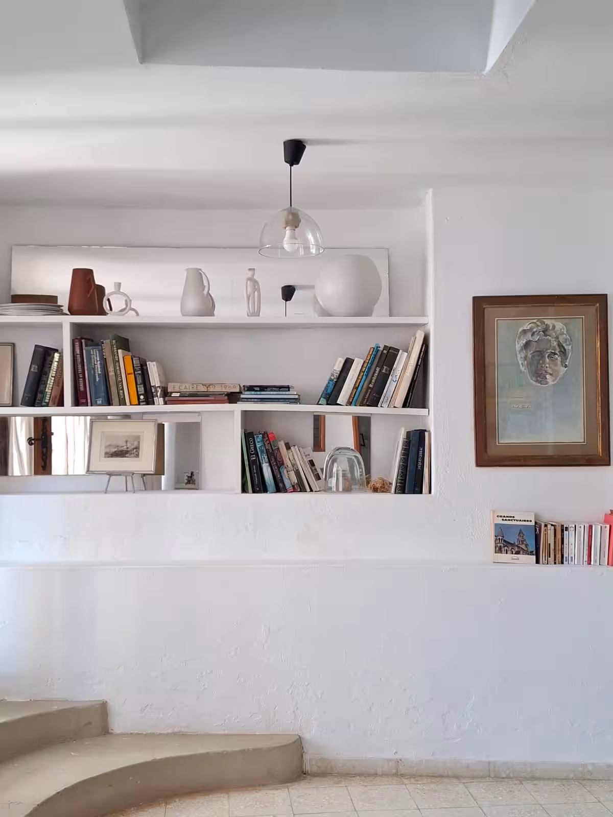 Niches de bibliothèque de L'Atelier, céramiques et portrait encadré