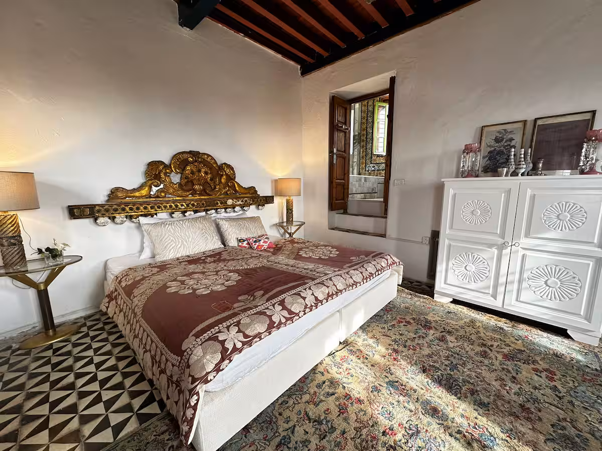 Chambre du niveau bas de la tour, plafond de bois et tête de lit dorée