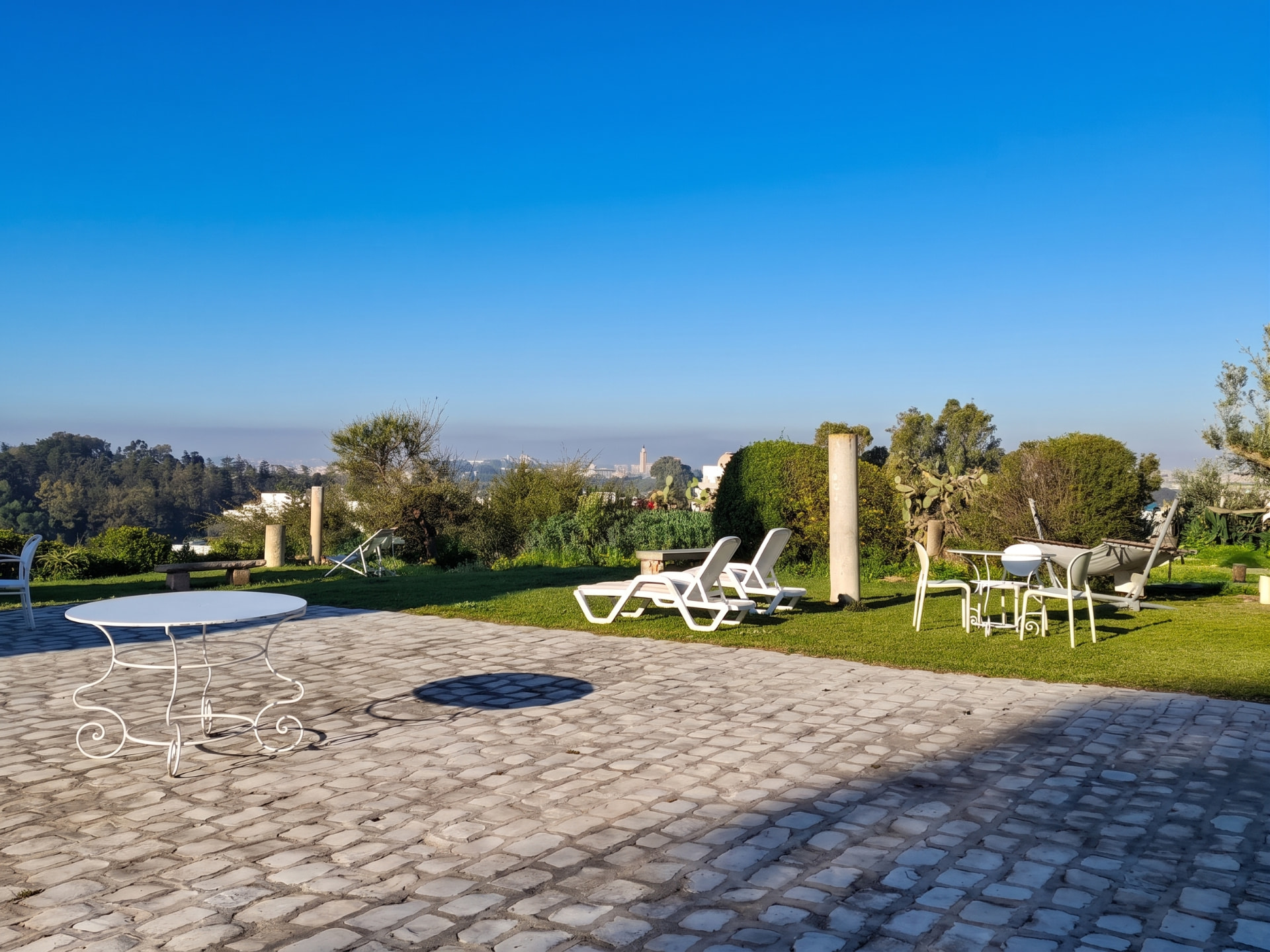 Terrasse pavée de Dar Turki avec transats et vue sur la baie