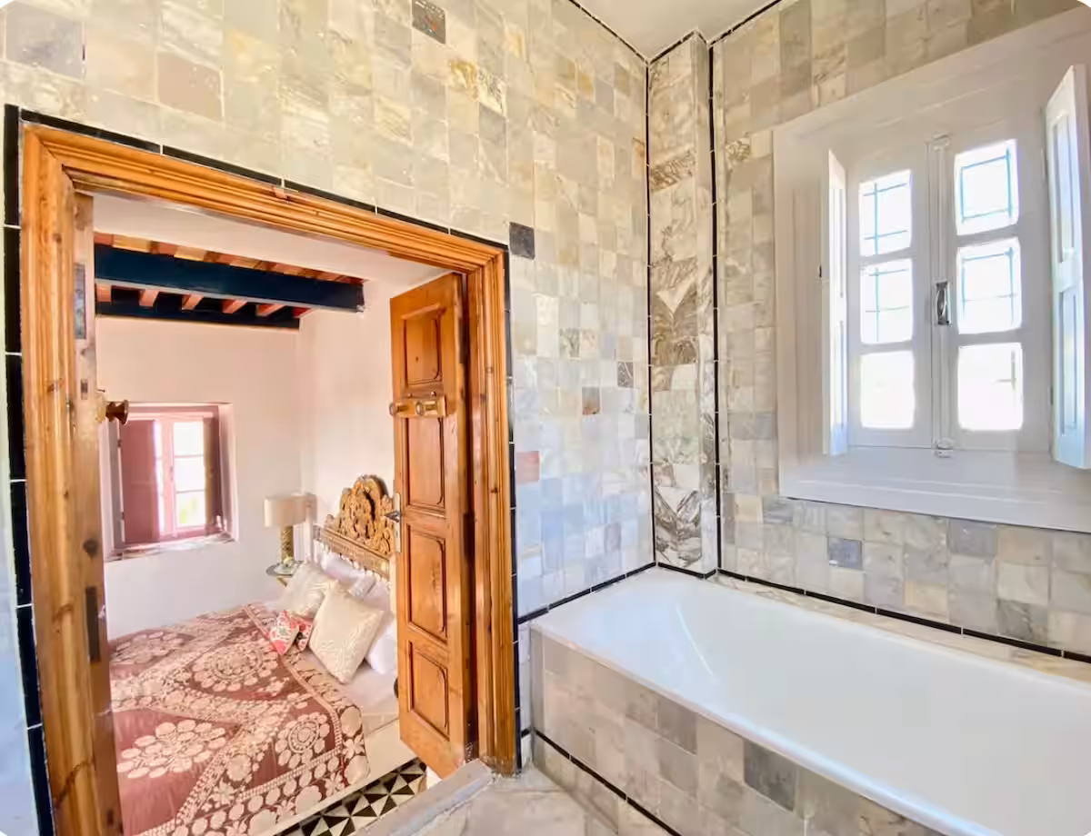 Salle de bains de la suite Princesse Aïcha, baignoire sous la fenêtre et marbre ancien