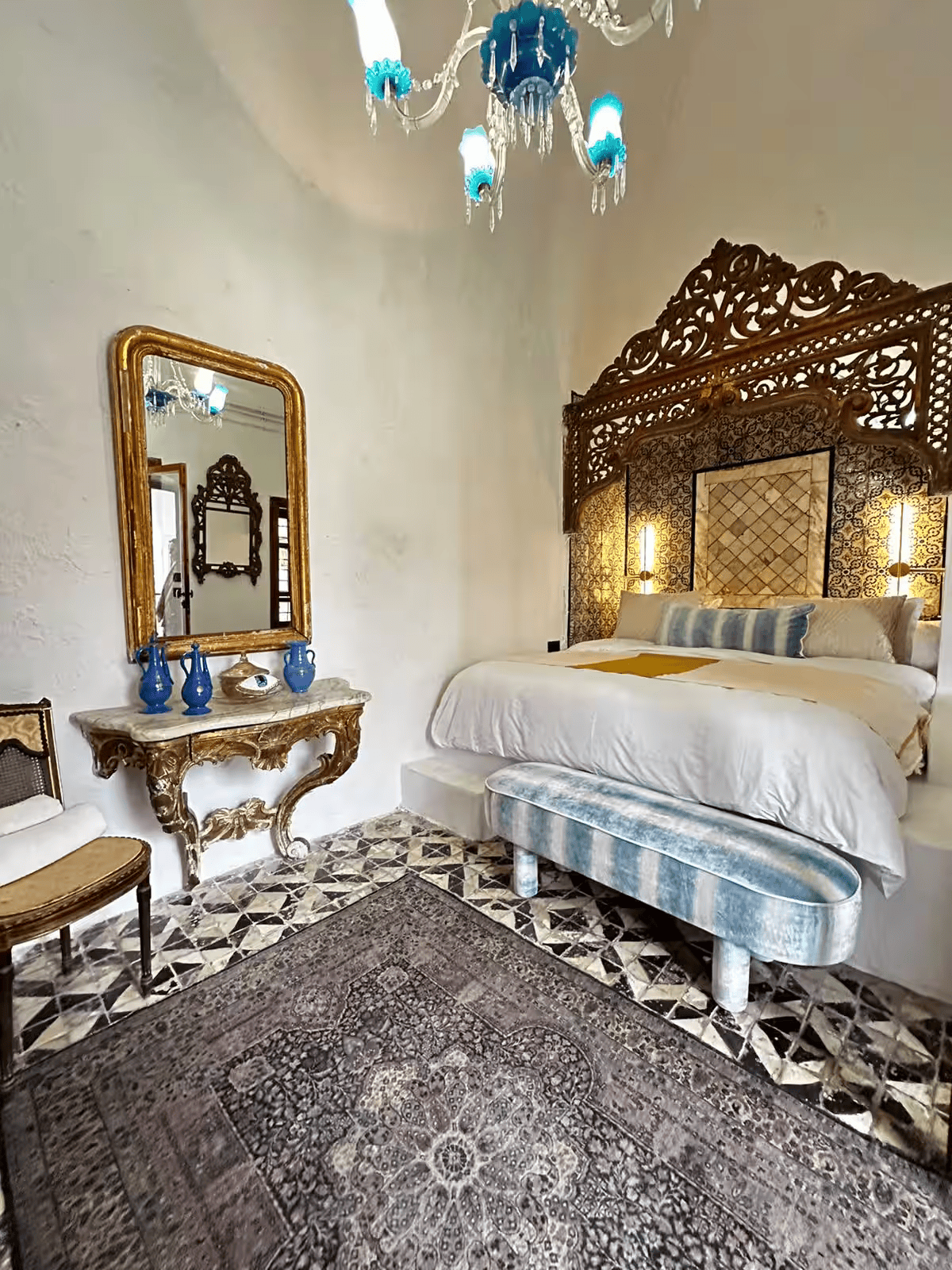 Chambre de la suite Noor, tête de lit sculptée dorée, miroir et console anciens
