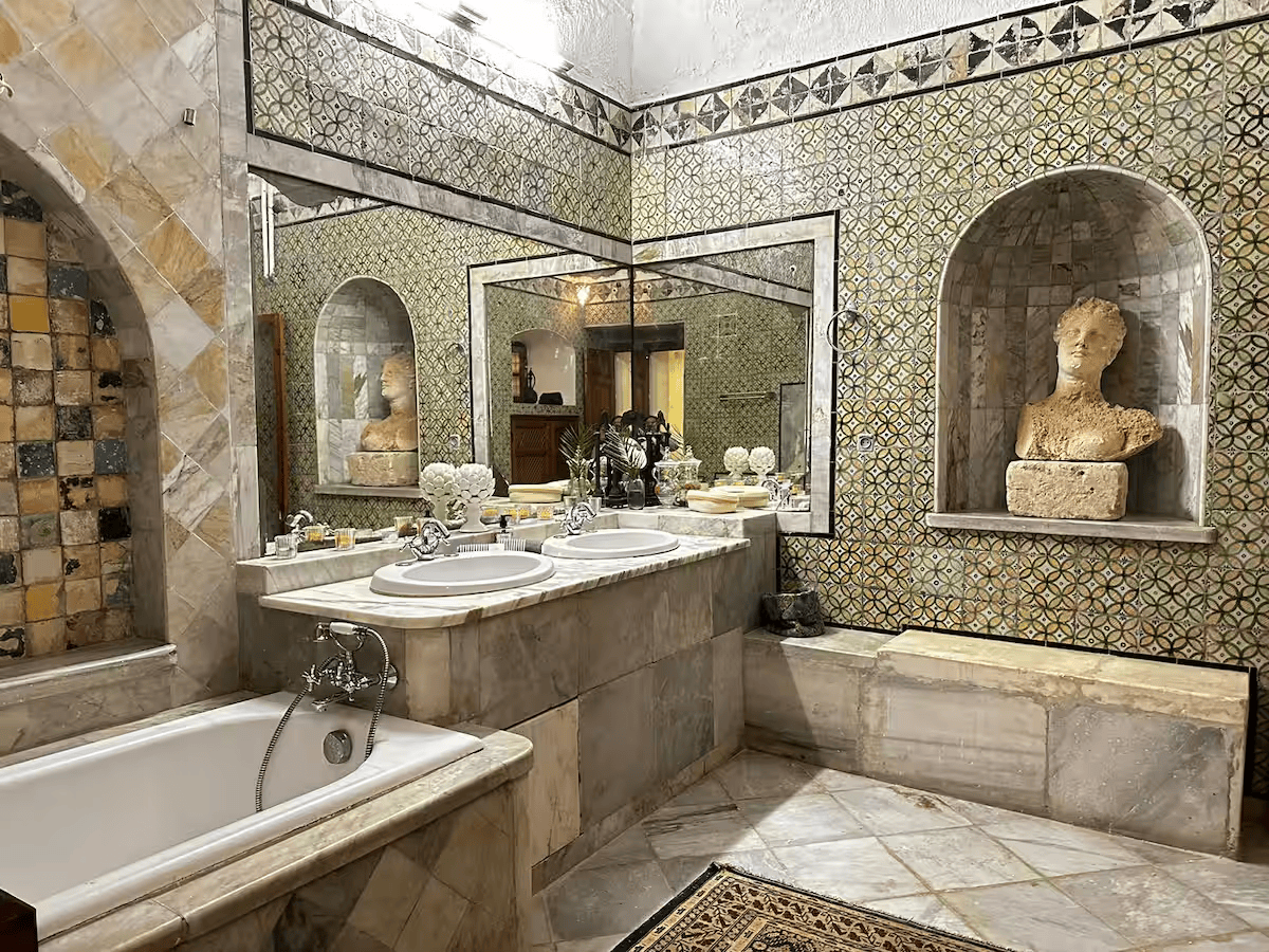 Baignoire et buste antique dans la salle de bains de la suite Noor