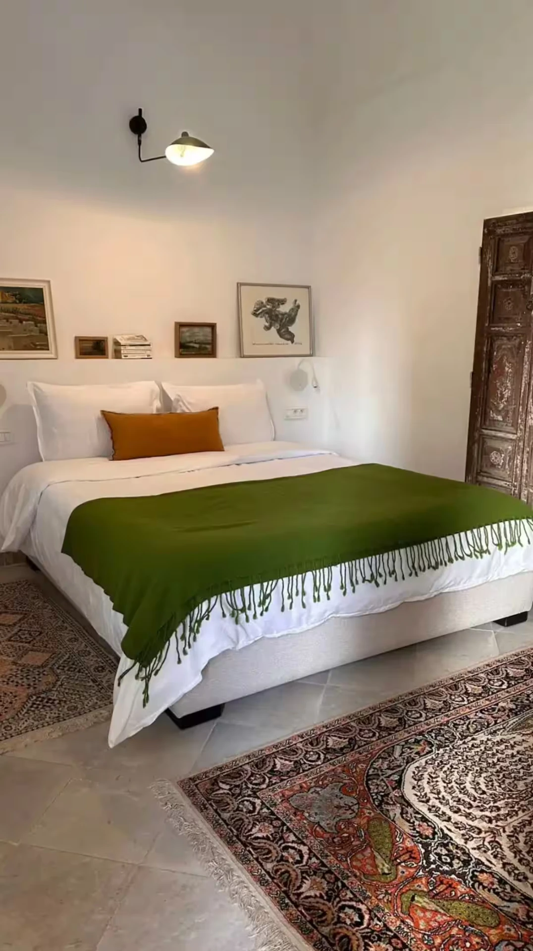 Lit blanc de Lella Zohra, étoffe verte et tapis anciens