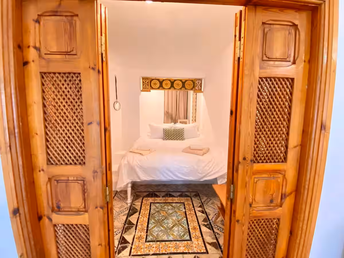 Portes de bois sculpté ouvertes sur la chambre de L'Atelier