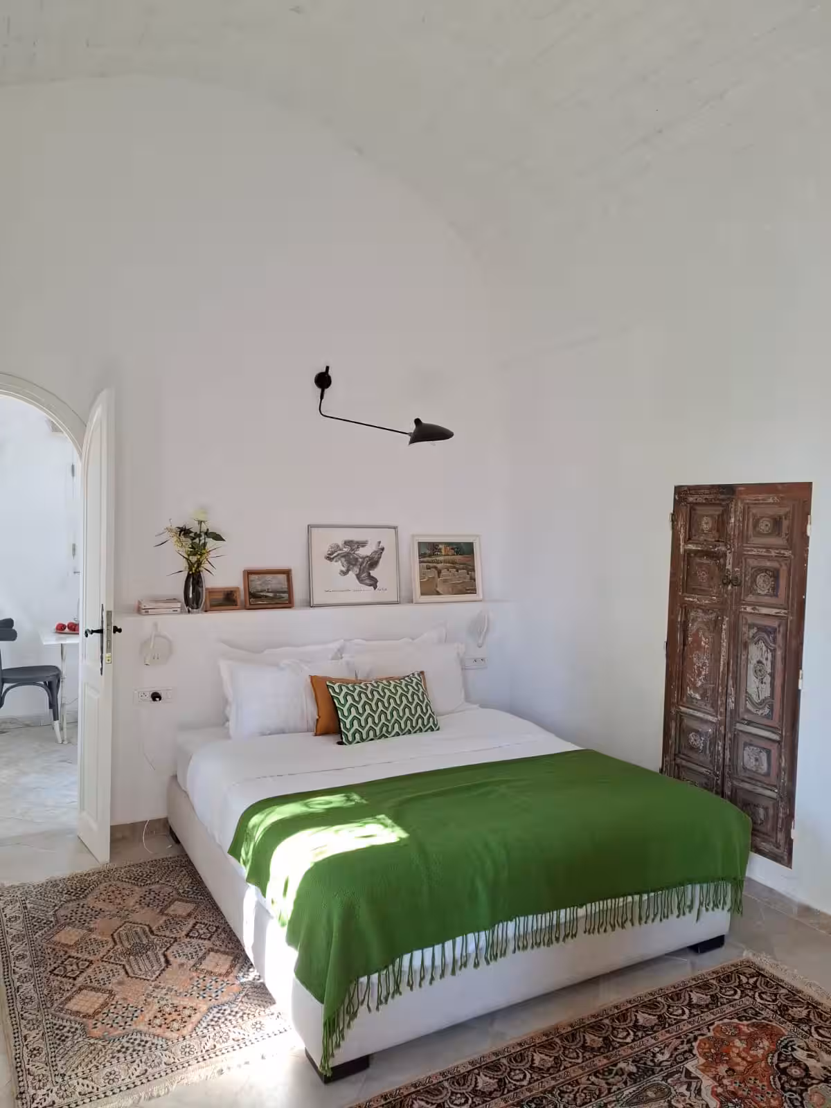 Chambre Lella Zohra vue depuis l'angle, tapis anciens et porte sculptée