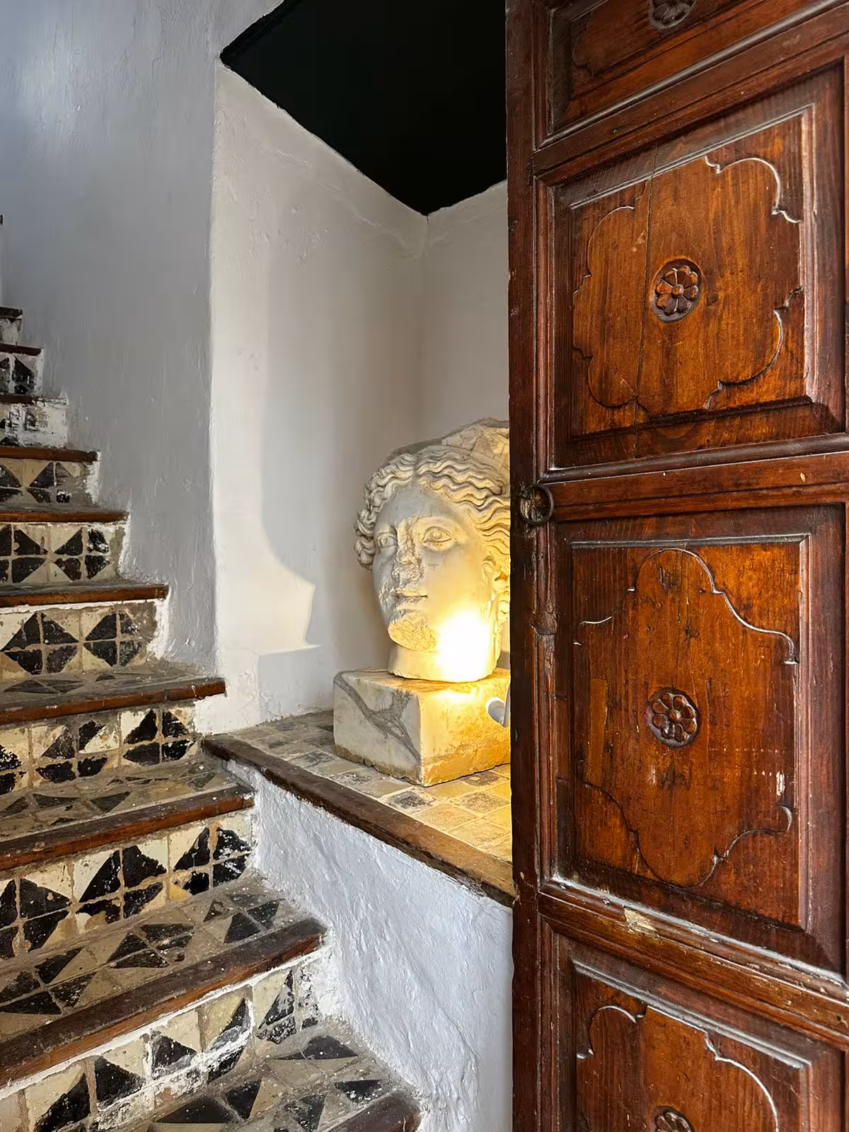 Escalier de la tour et tête de marbre antique posée sur une console