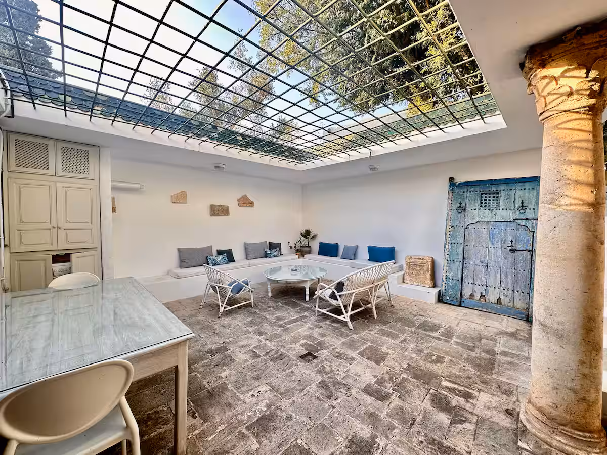 Patio privé de L'Atelier sous verrière et treillis, porte bleue ancienne
